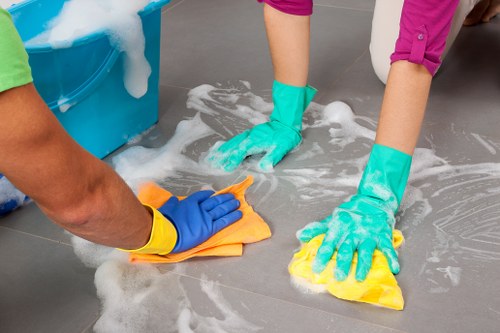 Cleaner maintaining a bright building entrance during communal area cleaning