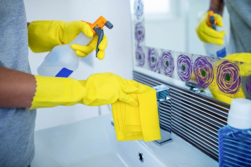 Professional cleaner disinfecting high-touch surfaces in a workplace